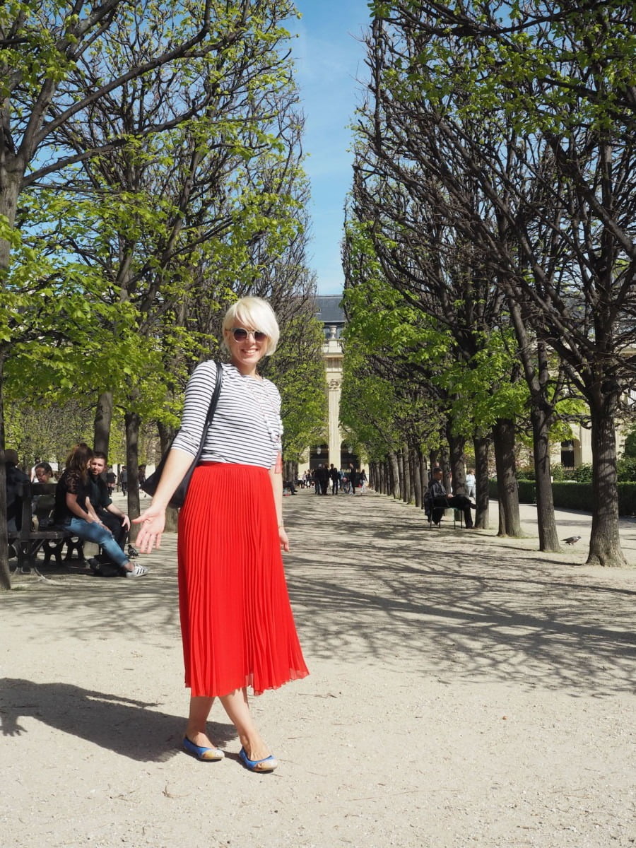Maxine standing among some trees in Paris