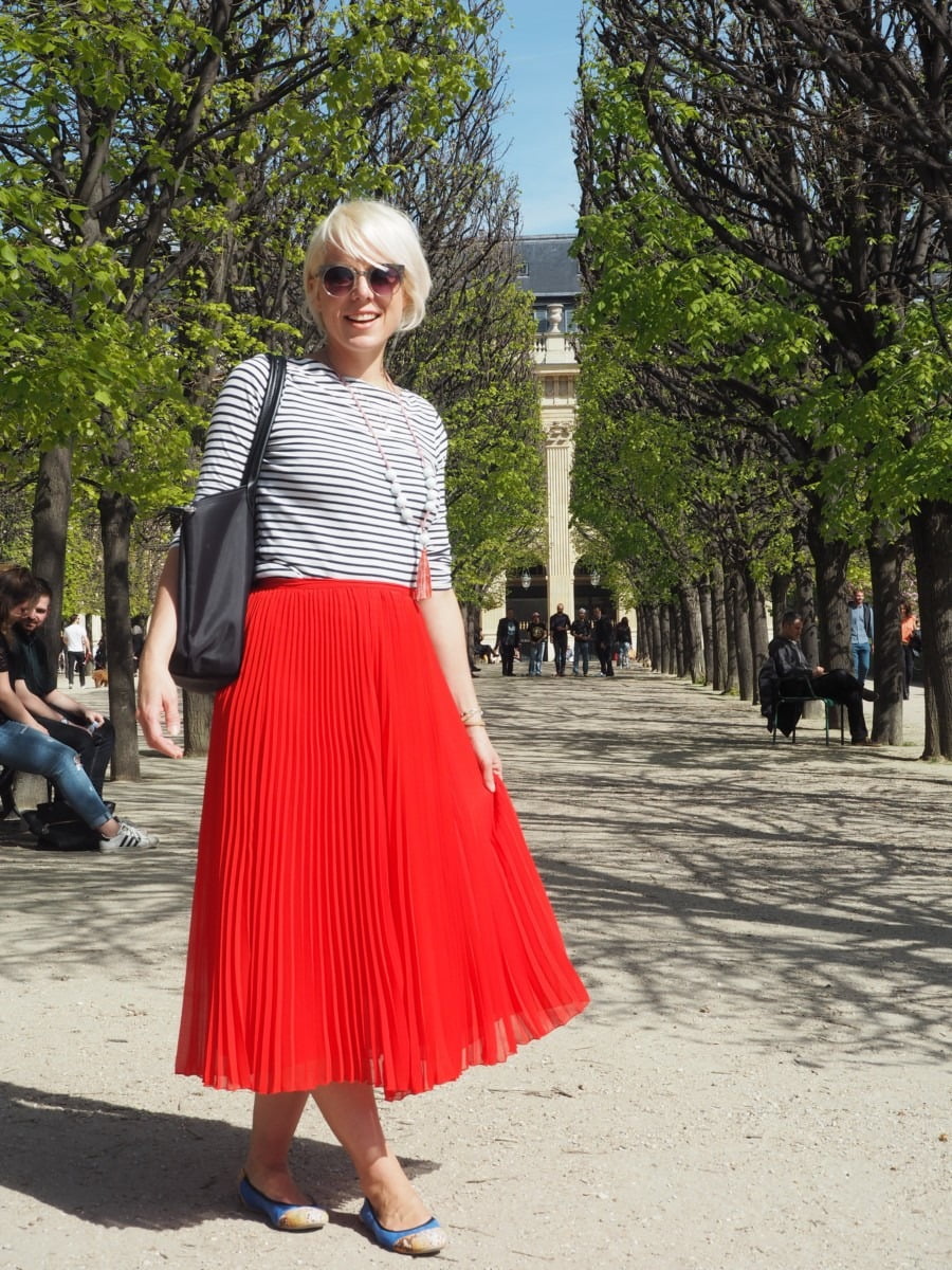 Maxine posing with a striped top and red dress