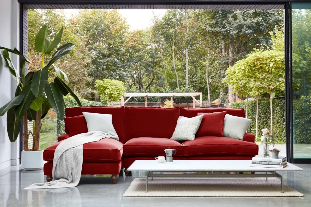 Discover these top 5 buyer's tips for buying a corner sofa by interior stylist and lifestyle blogger Maxine Brady from We Love Home Blog. Red orange velvet corner sofa with fig plant in garden room, conservatory with garden and coffee table and polished concrete floors and crittal windows