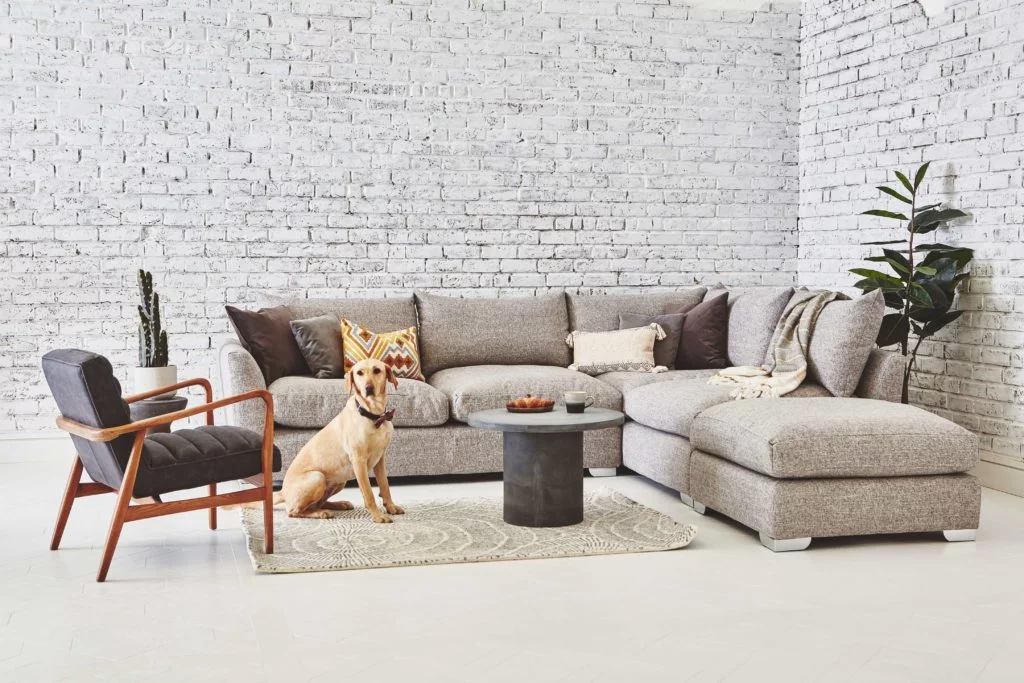 Discover these top 5 buyer's tips for buying a corner sofa by interior stylist and lifestyle blogger Maxine Brady from We Love Home Blog. white corner sofa with retro furniture in living room with brick wall