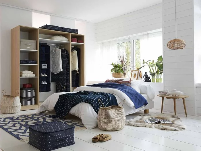 Discover how to tackle your bedroom clutter with these 6 stylish bedroom storage solutions for your home by interior stylist Maxine Brady. Blue bedroom with lots of clever storage ideas with white painted floorboards.