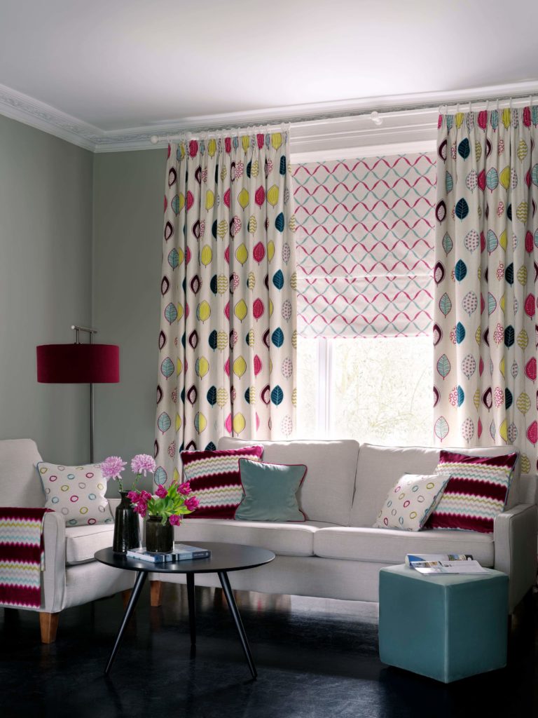 bold colourful window dressing in a living in blue, red and natural curtains and blinds