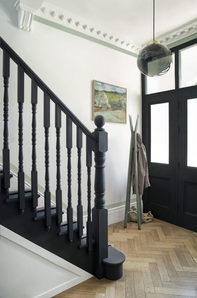 hallway with painted banister and black door