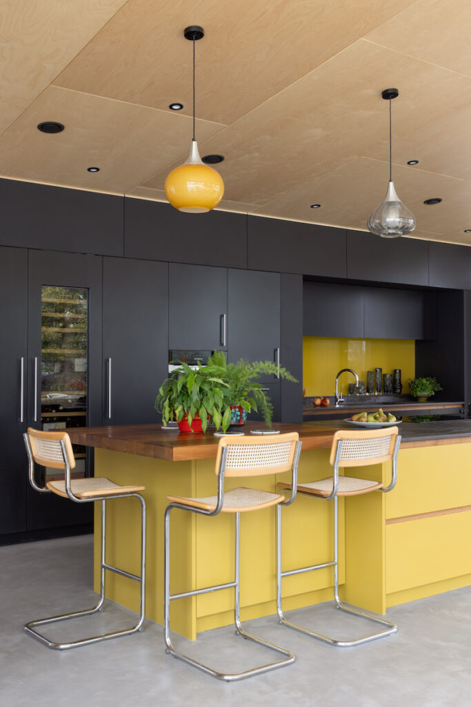 Be inspired by these 7 colourful kitchens - all new for 2024.
navy kitchen. navy and yellow kitchen. cane chairs. 