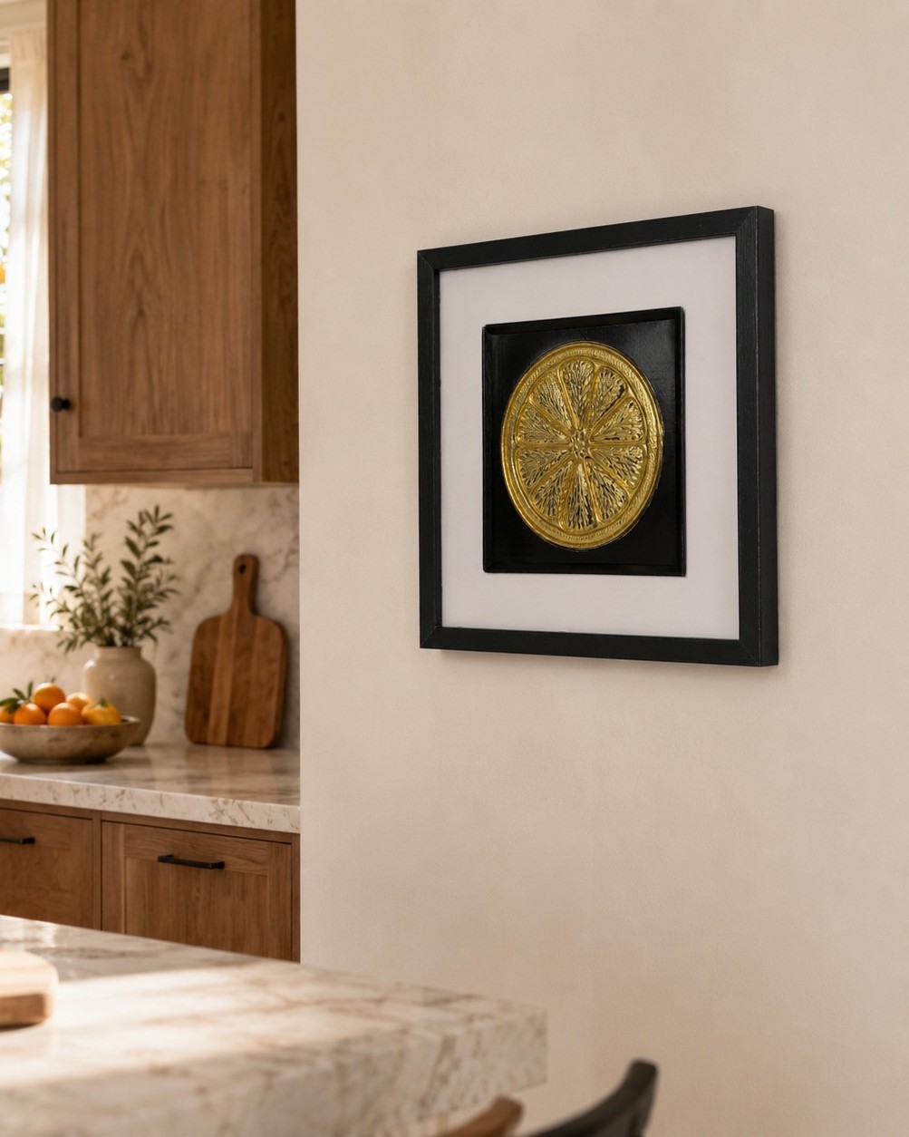 How to choose wall art for your home: Framed gold kitchen wall art styled above a marble worktop in a warm contemporary kitchen